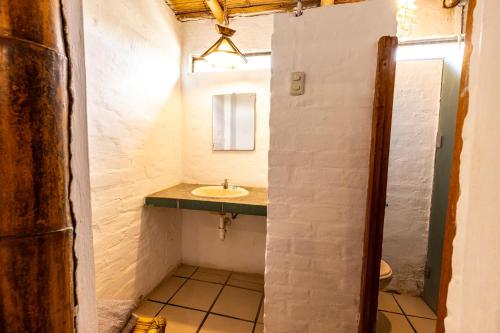 a bathroom with a sink and a mirror at Mamaqocha in Canoas de Punta Sal