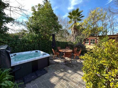 a hot tub in a yard with a table and chairs at Porters Cottage Garden in Albury