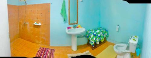 a blue bathroom with a sink and a toilet at Haranai Camping & Tours in Te-Fare-Arii