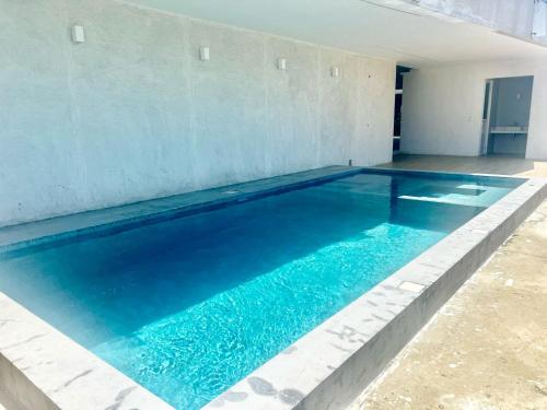 a swimming pool with blue water in a building at Departamento al pie del mar - Punta Blanca in Punta Blanca