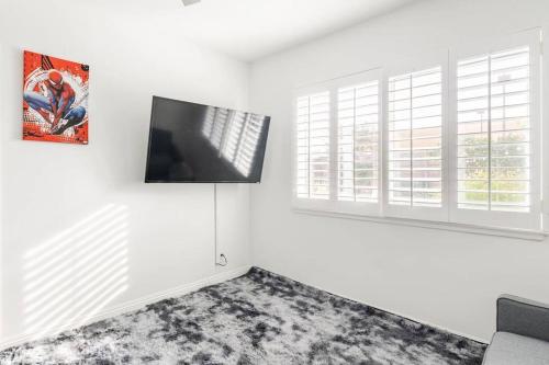 a living room with a flat screen tv on a wall at Family Home by Disney+Knotts, Pool,Game Room in Fullerton