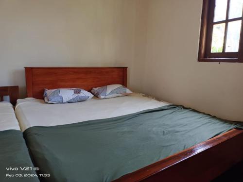 ein Bett mit zwei Kissen darauf in einem Schlafzimmer in der Unterkunft NSM Wedding hall and guest room 