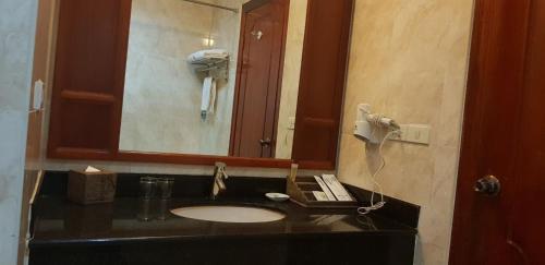 a bathroom with a sink and a mirror at Ree Mohasambath Hotel & Resort in Phumĭ Thnál