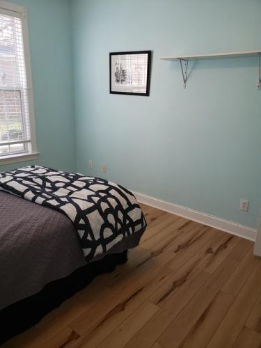 a bedroom with a bed and a wooden floor at Long Term Retreat Haven in Chapel Hill