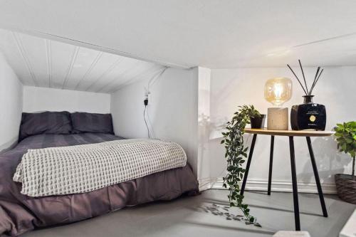 a bedroom with a bed and a table with a lamp at Elegant private room Oslo Central - Grunerløkka 1km from Oslo S Station in Oslo