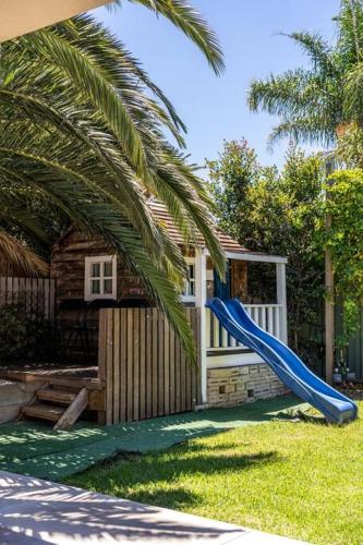 a blue slide in a yard next to a house at Marble at South Plympton - 4BR Modern WiFi in South Plympton