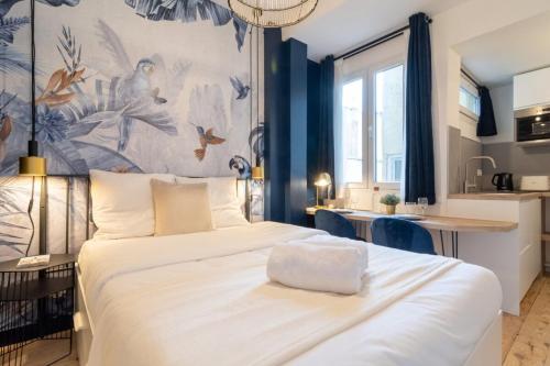 una camera con un grande letto bianco e una cucina di Equipped studio in the center of Lille a Lille