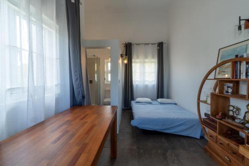 a bedroom with two beds and a wooden table at El-Sangha Studio 2mina pieds de la plage de baie du cap in Baie du Cap