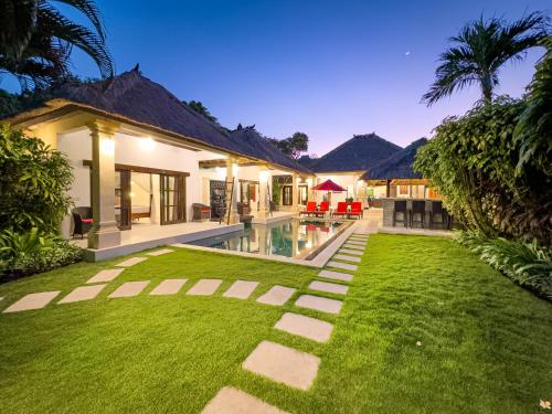 an exterior view of a house with a lawn at Villa Bugis Seminyak in Seminyak