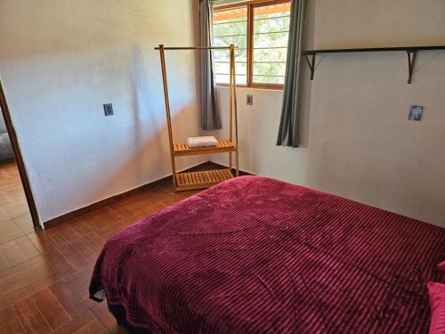 um quarto com uma cama com uma colcha vermelha em Departamento em San Miguel