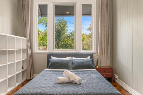 a bedroom with a bed with a pillow on it at Unique Character Queenslander Home! Just Minutes to CBD & South Brisbane in Brisbane