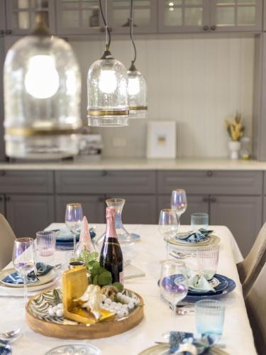 a table with plates of food and a bottle of wine at Heritage Queenslander Gem - Families & Groups - Minutes to CBD & South Brisbane in Brisbane