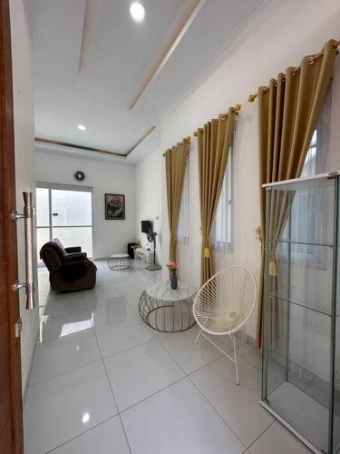 Mahardika Homestay Gamping في سليمان: غرفة معيشة مع أريكة وكرسي