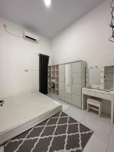 Mahardika Homestay Gamping في سليمان: غرفة بيضاء مع سرير ومكتب