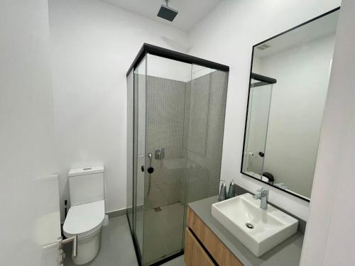 een badkamer met een toilet, een wastafel en een douche bij Five Stars Suites - Gótica - iQON Quito in Quito