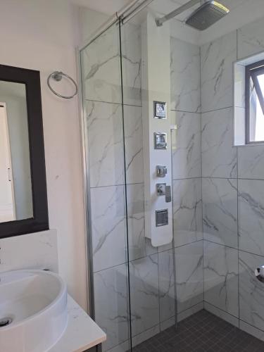 a bathroom with a shower and a sink at Studio Apartment in Glencairn in Cape Town