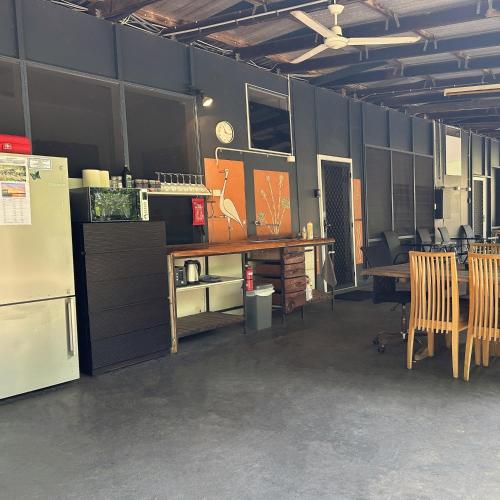 a room with a refrigerator and a table and chairs at Unit 2 Golden Sands Retreat in Wagait Beach