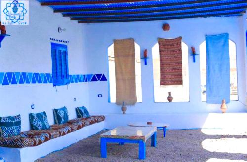 a living room with a couch and a table and windows at Asilah kato nubian guest house in Aswan