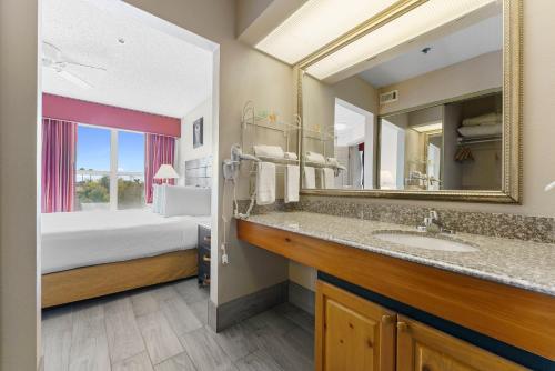 a bathroom with a sink and a bed and a mirror at Metro Scottsdale Promo 1 bd 1 in Scottsdale