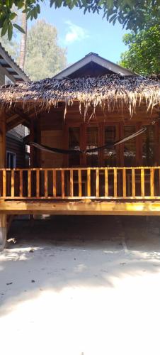 a wooden bench sitting in front of a building at Lazy Hut in Ko Phayam