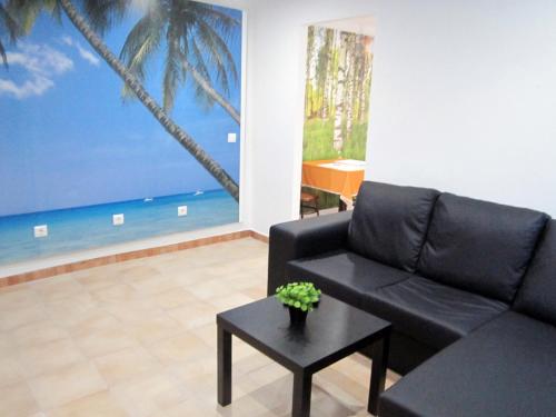 a living room with a black couch and a table at Alojamento Local Duarte's in Coimbra