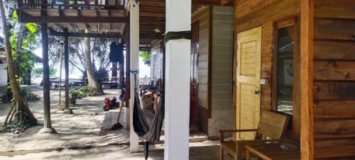a woman taking a picture of the outside of a house at Lazy Hut in Ko Phayam