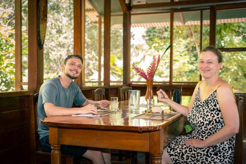 un hombre y una mujer sentados en una mesa en un restaurante en Passiflora Camp, en Puerto Maldonado