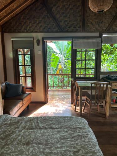 a bedroom with a bed and a table and chairs at Santai House in Tetebatu