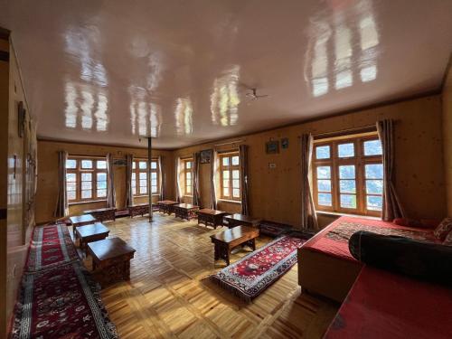 SNOWFLAKE Homestay في Gondla: غرفة كبيرة مع طاولات ونوافذ في مبنى