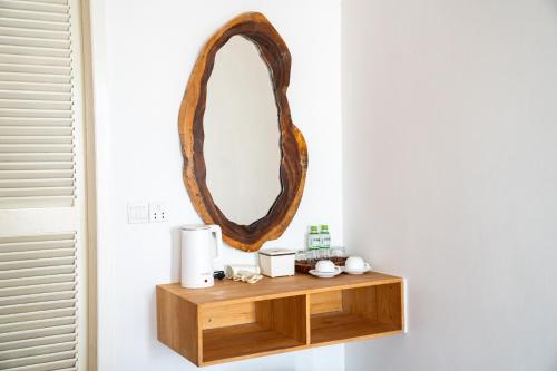 a wooden shelf with a mirror on a wall at One Beach Resort By EHM in Koh Rong Sanloem