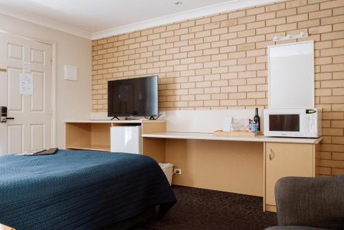 ein Hotelzimmer mit einem Bett und einem TV in der Unterkunft Alexandra Place in Bendigo