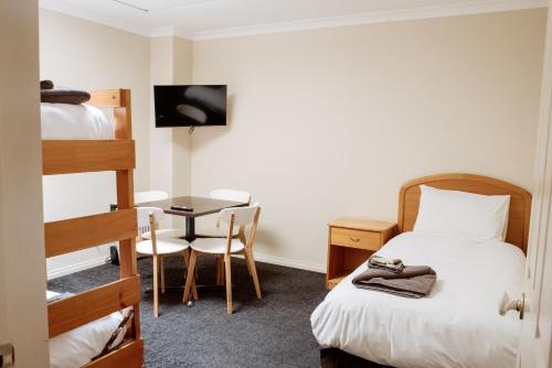 a bedroom with a bed and a desk and a bunk bed at Alexandra Place in Bendigo
