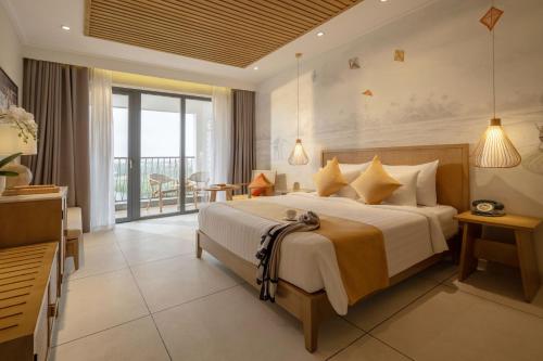 1 dormitorio con 1 cama grande y balcón en Little Oasis - An Eco Friendly Hotel & Spa en Hoi An