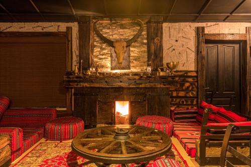 a room with a fireplace and red chairs and a table at The Forest and Lake by Schofieldshire in Nuwara Eliya