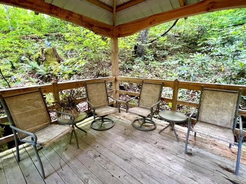 a porch with chairs and a table on it at Streamsong Secluded Creek View Cabin in Hatchertown