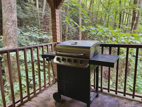 a grill sitting on a porch on a deck at Streamsong Secluded Creek View Cabin in Hatchertown