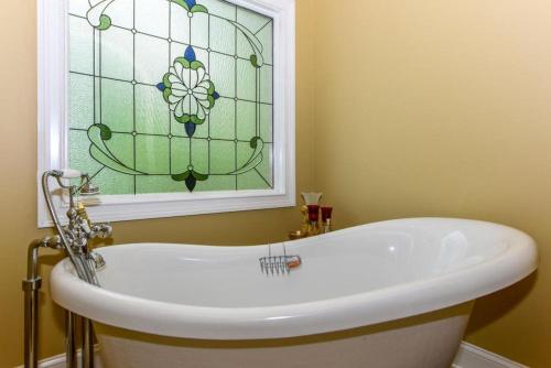 y baño con bañera y vidriera. en Enchanted Primrose Chalet #3709 Chalet, en Sevierville