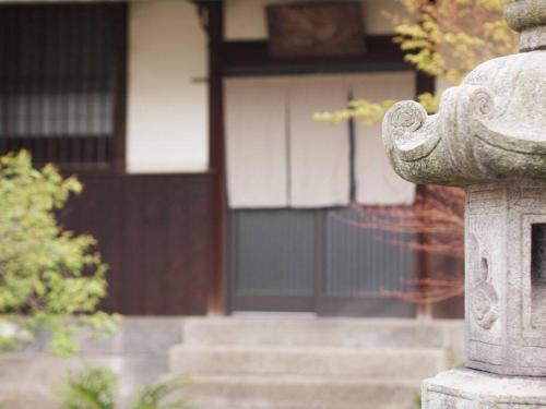 a stone fire hydrant in front of a building at 日々の宿: 宇野駅から車で5分 直島へ 最大7名様 古民家貸切 一棟貸し in Tama