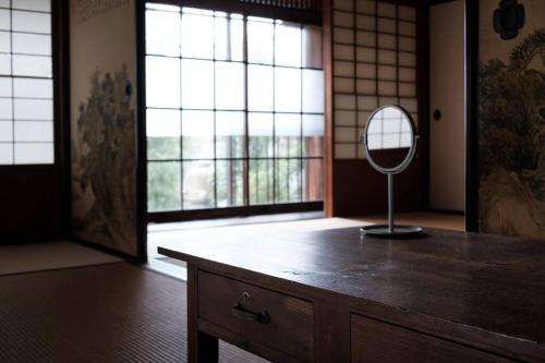 a mirror on a dresser in a room with windows at 日々の宿: 宇野駅から車で5分 直島へ 最大7名様 古民家貸切 一棟貸し 