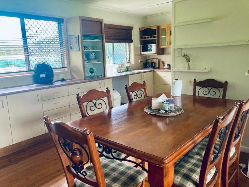 a kitchen with a wooden table and wooden chairs at lavender cottage three large bedroom house in Mount Tamborine