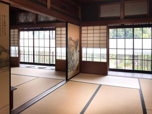 a room with three windows in a building at 日々の宿: 宇野駅から車で5分 直島へ 最大7名様 古民家貸切 一棟貸し in Tama
