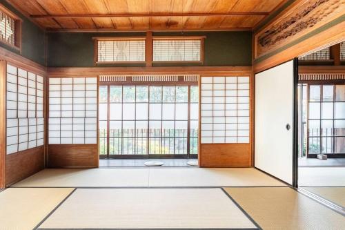 an empty room with large windows and doors at 日々の宿: 宇野駅から車で5分 直島へ 最大7名様 古民家貸切 一棟貸し in Tama