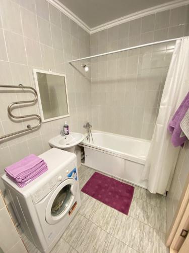 - un lave-linge dans la salle de bains pourvue d'un lavabo et d'une baignoire dans l'établissement Алтын Шар2, à Taldykolʼ