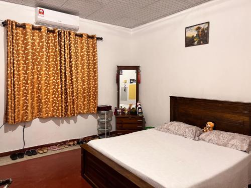 1 dormitorio con cama y espejo en Cozy village house en Tudugalla