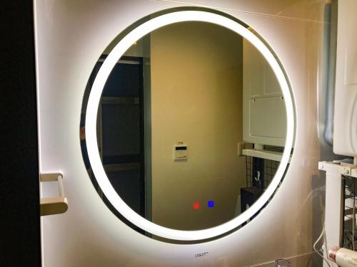 a round mirror on a wall in a bathroom at Niruyakanaya BISE - Vacation STAY 36708v in Bise