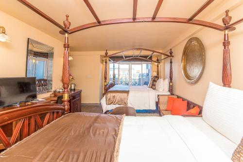a bedroom with a four poster bed and a television at The Forest and Lake by Schofieldshire in Nuwara Eliya