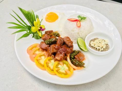 a plate of food with eggs and tomatoes and rice at Green Valley Veal Pouch in Kampot