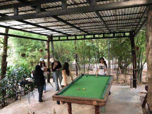 a group of people standing around a pool table at Green Valley Veal Pouch in Kampot