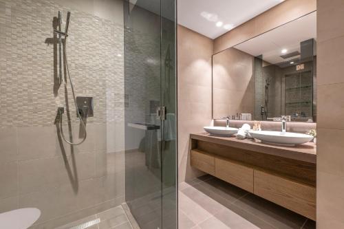 a bathroom with two sinks and a shower at Jumeirah Marina Gate Residences in Dubai