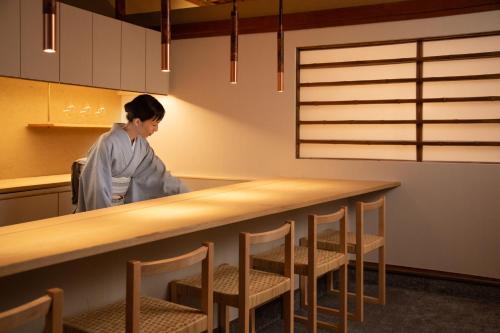 a woman standing behind a table in a kitchen at Mitsuki Kyoto in Kyoto